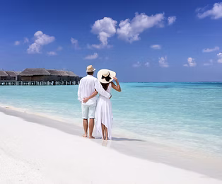 Coppia in viaggio di nozze alle Maldive che si gode una vacanza romantica sulla spiaggia tropicale